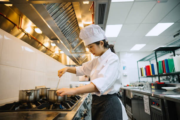 istock Asian Female Chef Cooking In Kitchen. 2103887725