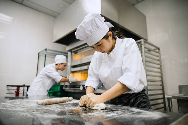 istock Asian Female Chef Making Bread In Kitchen. 2103888775