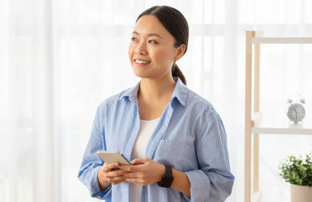 istock Interested korean lady with smartphone in her hands, copy space 2103896174