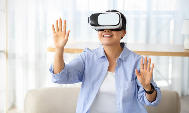 istock Chinese lady experiencing virtual reality session at home 2103896713
