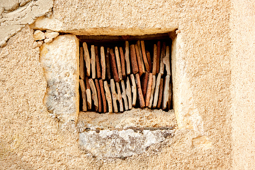 Tiles Placed Vertically in a Square Hole in a Stone Wall