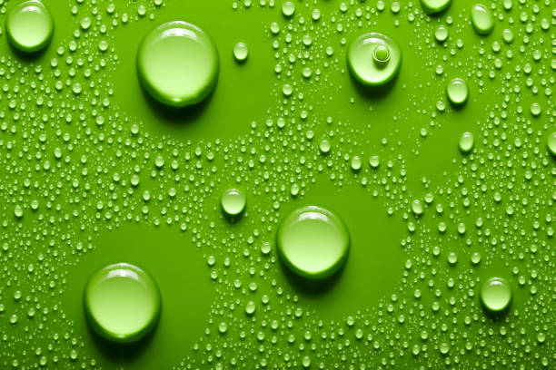 istock Small and large drops of water on a colored background. Abstract liquid sprays 2103900442