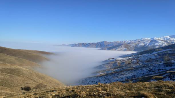 village house on the edge of a fog-covered valley among snowy mountains - street fog profile zdjęcia i obrazy z banku zdjęć