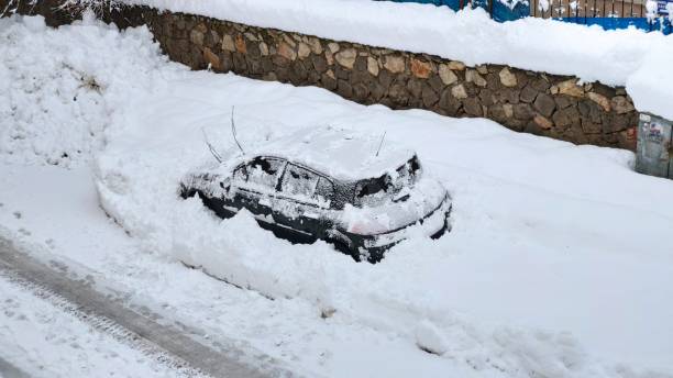 istock A parked black car covered in snow 2103913456