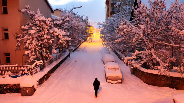 istock man walking alone on snowy street 2103915533
