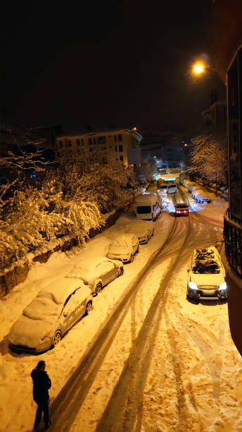istock walking alone on the snowy street at night 2103917802