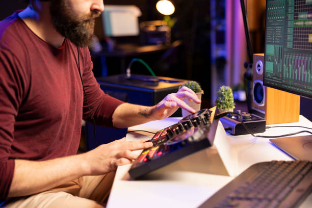 istock Music producer creating new tunes on mixing console by twisting pre amp knobs 2103955760