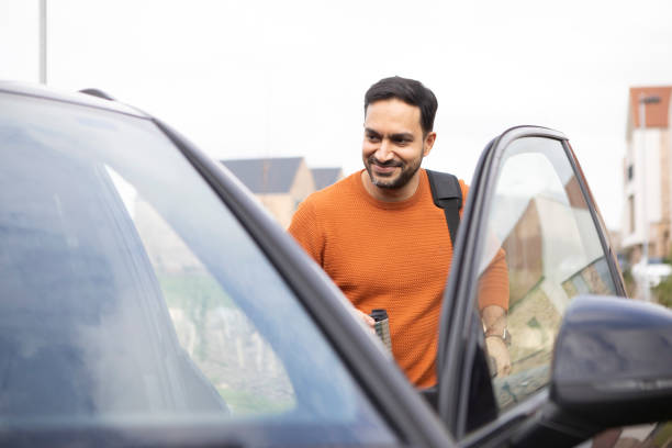 istock Male passenger getting in a car door 2103960930