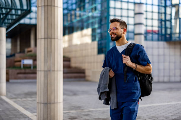 istock Smiling male surgeon standing outdoors while looking away. 2103969697