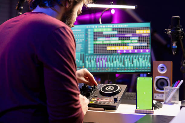 istock Music producer uses controls and knobs on mixing console in home studio 2103971782