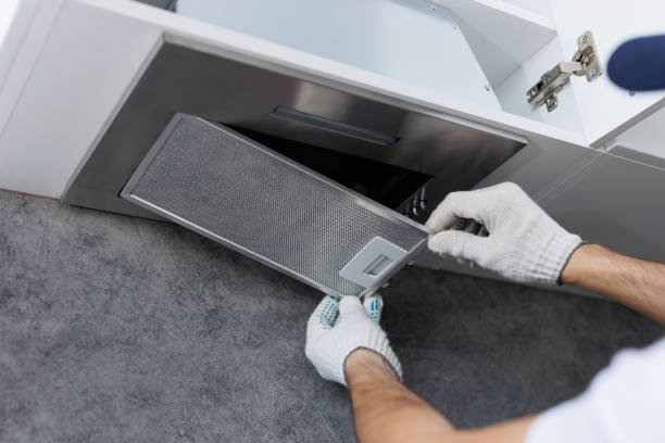 istock Mans hands removing a filter from cooker hood for cleaning. Replacing filter in kitchen hood. 2103972300