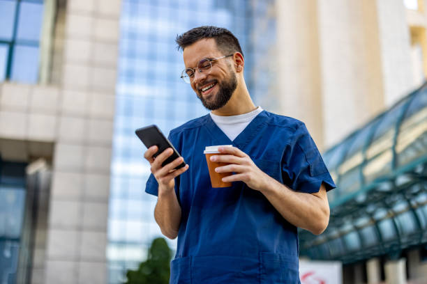 istock Male Nurse Using Smartphone On Coffee Break 2103975951