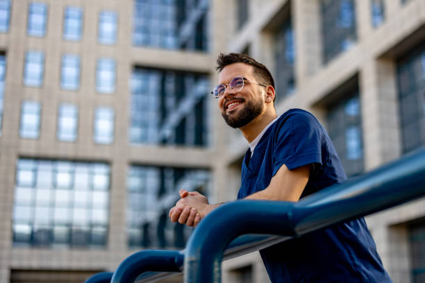 istock Confident male nurse standing outside looking away 2103983211