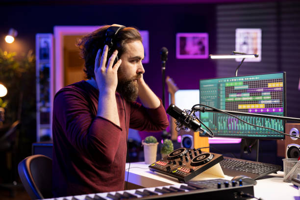 istock Skilled confident musician editing tunes with daw software on microphone 2103983737