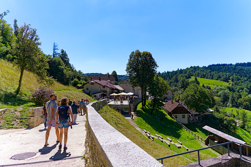 Visitors at Predjama castle with scenic landscape on a sunny summer day. Photo taken August 11th, 2023, Predjama, Slovenia.