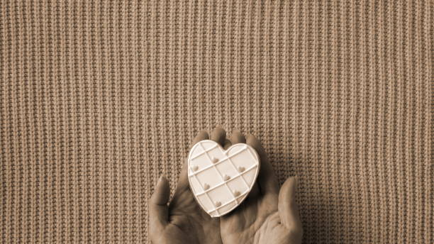 istock Treasured Love in Sepia Tones. A Heart-Shaped Token Cradled Gently Against a Textured Background 2103998946