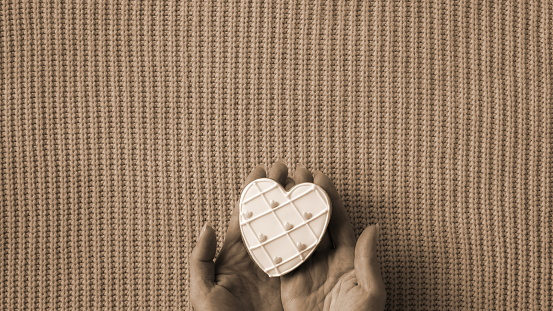 Treasured Love in Sepia Tones. A Heart-Shaped Token Cradled Gently Against a Textured Background. Old Photo