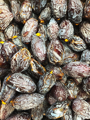 Dried Dates Close-Up: A Pile Of Wrinkled Dates Rich In Color And Texture. The Photo Captures The Natural Sweetness And Detail Of The Dried Fruit