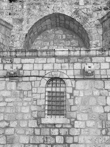 Monochrome Historic Architecture: Arched Entryway With Barred Window In A Stone Wall. The Vertical Black And White Image Portrays The Timeless Beauty Of Classical Mason Work
