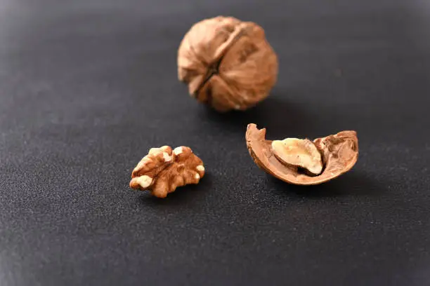 Walnut and walnut shell on dark background.