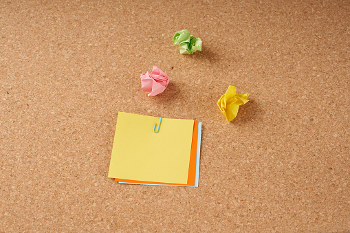 Several multi-colored sheets of paper fastened with a paper clip.