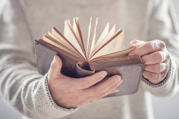 istock Man holding reading open book or holy bible 2104018706