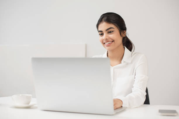 istock Woman working in office. Student girl using laptop computer at home 2104018717