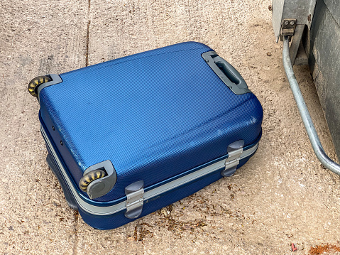 A pile of battered, leather, vintage suitcases on a luggage trolley