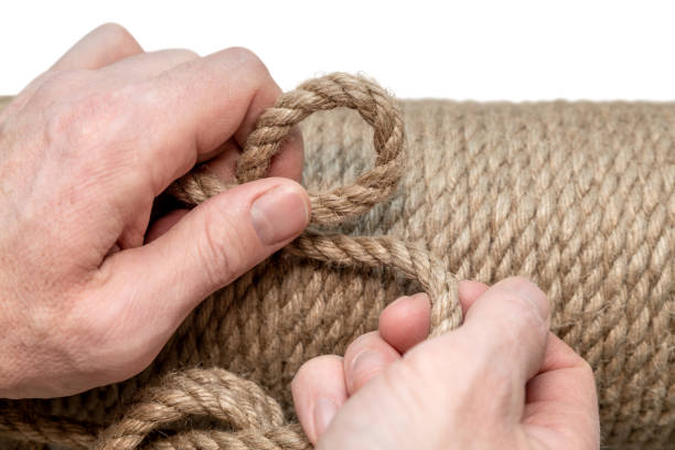 Jute rope close-up in a man's hand. Background made of natural organic threads. Environmentally friendly Material for creativity. Made from the Corchorus capsularis plant. Cat scratching post. cuerda de yute en primer plano en la mano de un hombre. fondo fabricado con hilos orgánicos naturales. material respetuoso con el medio ambiente para la creatividad. elaborado a partir de la planta corchorus capsularis. poste rascador para gatos.