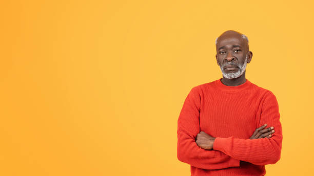 istock Confident senior man with a warm smile, wearing a red sweater and a hat 2104160757