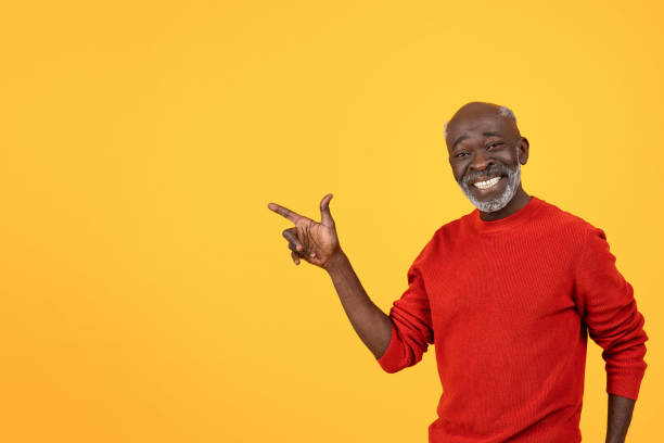 istock Happy senior Black man with a white beard, pointing to the side with a big smile 2104161326