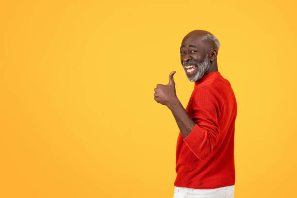 istock Enthusiastic senior Black man with a white beard giving a thumbs up sign, turning back with a big smile 2104161331