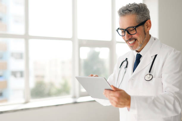 istock Experienced confident senior doctor with grey hair using tablet 2104166295