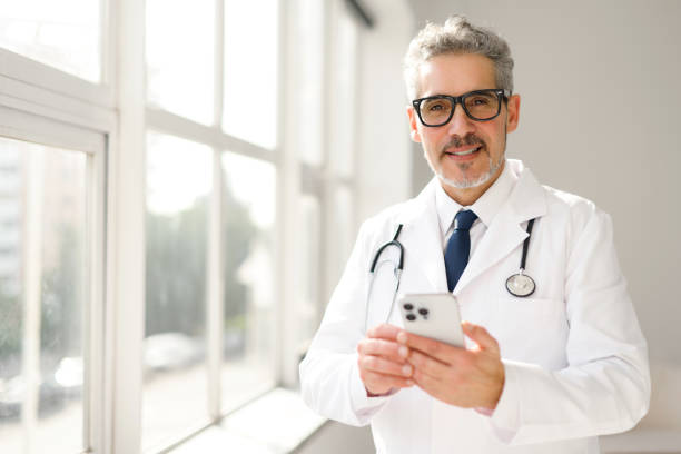 istock In a bright, modern clinic, a senior doctor is seen using a smartphone 2104166443