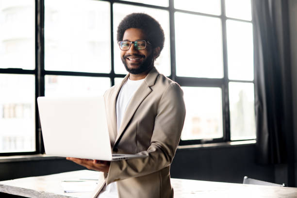 istock A modern Brazilian businessman smiles while working on his laptop 2104167896