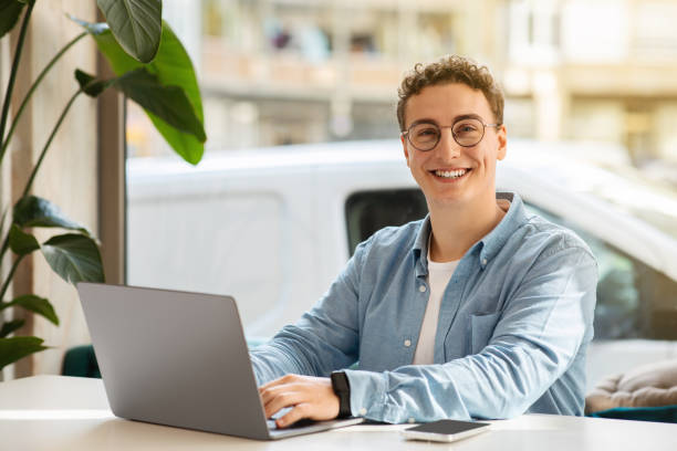 istock Smiling proud millennial european guy student in glasses, typing on computer 2104172676