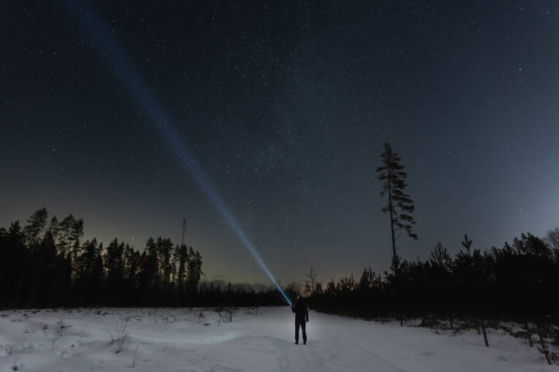 istock Night scene  in the forest. A man with a flashlight under the starry sky. 2104172713