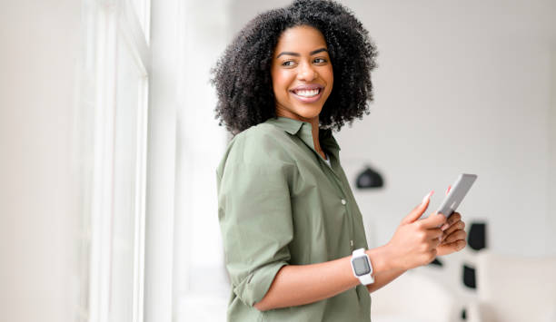 istock An African-American woman with a beaming smile uses a tablet 2104185821