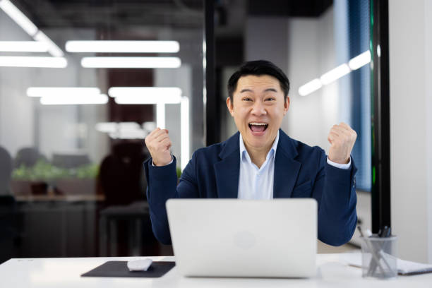 istock Joyful businessman celebrating success at the office 2104186881