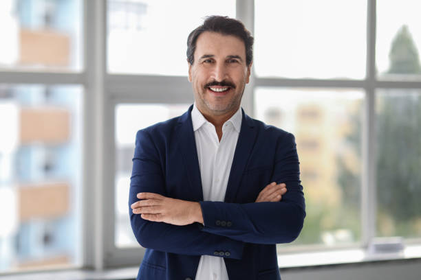 istock Confident middle-aged man with a mustache, wearing a blue suit and white shirt 2104194348