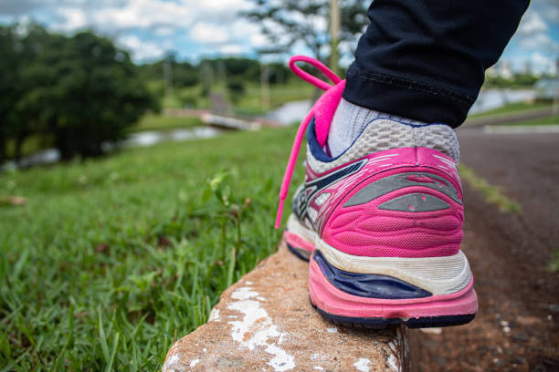 Rear view of a unrecognizable girl in sports shoe walking on a track