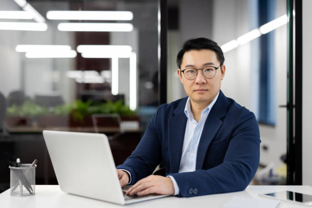 istock Confident asian business professional in modern office working on laptop 2104218871