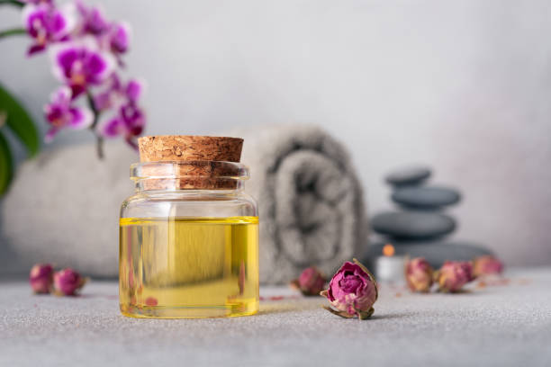 istock A serene spa still life featuring essential oils, smooth pebbles, a rolled grey towel, and a vibrant purple orchid 2104264304