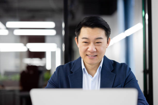 istock Confident businessman working on laptop in modern office 2104269062