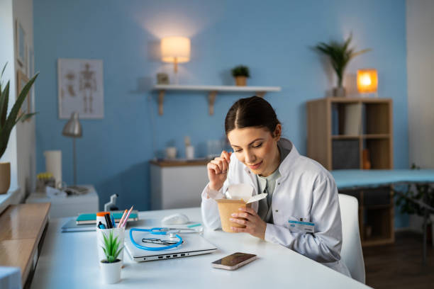 istock At the ordination, Caucasian female doctor using mobile phone during lunch break 2104282697