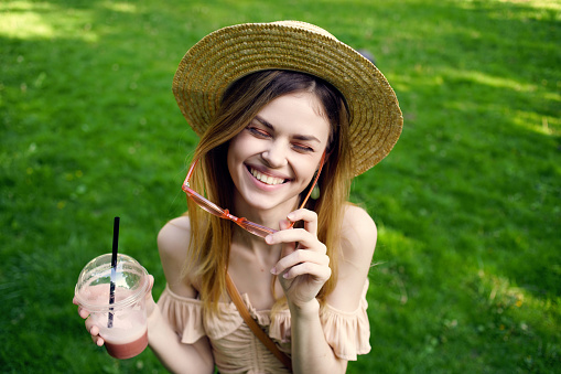 beautiful woman a glass with a drink in the park Lifestyle. High quality photo