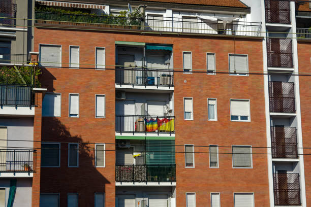 Cityscape with red brick wall apartment building and rainbow flag at Italian City of Milan on a sunny summer day. Photo taken August 11th, 2023, Milan, Italy.