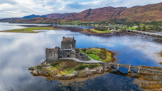 Dornie, Kyle Of Lochalsh Scotland: october 9th of 2023 - Eilean Donan Castle is a picturesque and iconic Scottish landmark, located on a small tidal island at the point where three sea lochs meet in the western Highlands of Scotland. The castle is recognized around the world and is one of the most visited and important attractions in the Scottish Highlands. The castle history is quite dramatic; it was partially destroyed in a Jacobite uprising in 1719 and lay in ruins for about 200 years. It was then restored to its former glory by Lieutenant Colonel John MacRae-Gilstrap, with the restoration completed in 1932