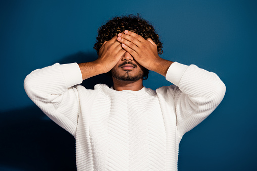 Photo of tired stressed man wear white sweater arms close eyes isolated dark blue color background.