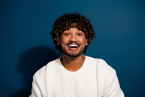Closeup photo of handsome mexican funny guy laughing when looking at you are joking humorous isolated on dark blue color background.